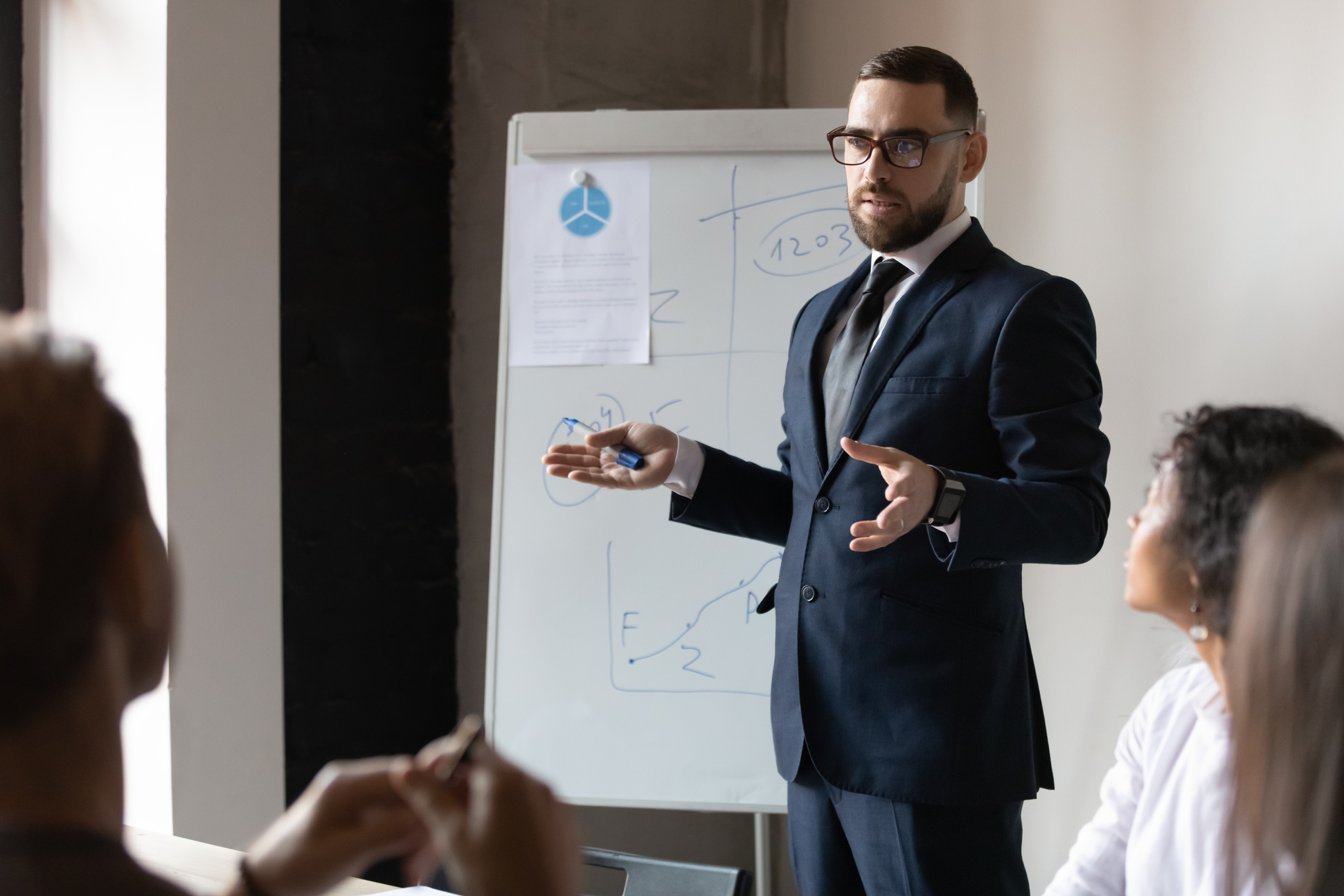 Confident male business trainer give presentation at office corporate training